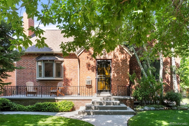 1265 S Elizabeth St, Denver, CO 80210 - view of front of house featuring roof with shingles, brick siding, and a front lawn