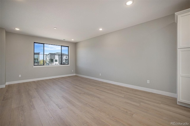 empty room featuring light wood-style flooring, recessed lighting, and baseboards