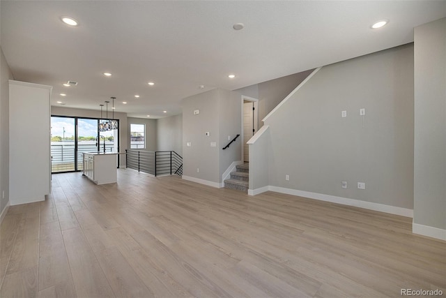 unfurnished living room with recessed lighting, baseboards, and light wood-type flooring