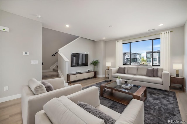 living room with visible vents, wood finished floors, recessed lighting, stairway, and baseboards