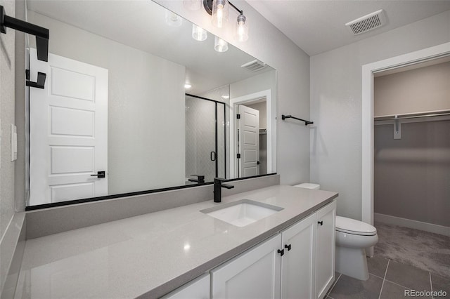 bathroom featuring a walk in closet, a shower stall, toilet, and visible vents