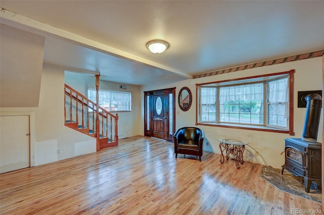 319 W Arkansas St, Buena Vista, CO 81211 - entrance foyer featuring wood finished floors, stairs, a wood stove, and beam ceiling