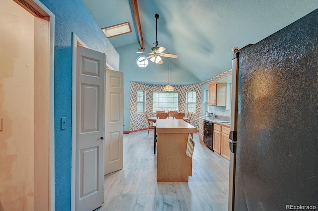 319 W Arkansas St, Buena Vista, CO 81211 - kitchen featuring light wood-style floors, a ceiling fan, freestanding refrigerator, a kitchen island, and dishwasher