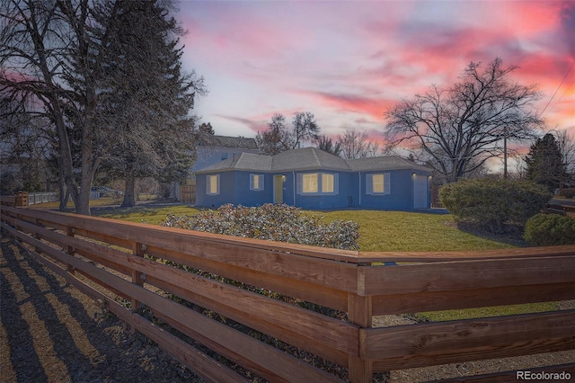 view of front of home with fence and a yard