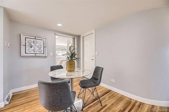 dining room featuring light wood finished floors, visible vents, and baseboards