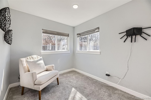 living area featuring carpet floors and baseboards