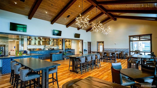 dining room with high vaulted ceiling, wooden ceiling, light hardwood / wood-style flooring, and a chandelier