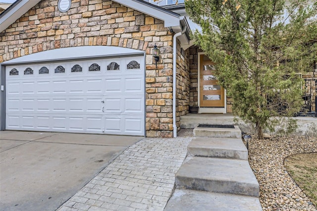exterior space featuring stone siding, driveway, and a garage