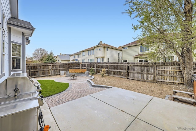 view of patio / terrace featuring an outdoor fire pit, a fenced backyard, area for grilling, and a residential view