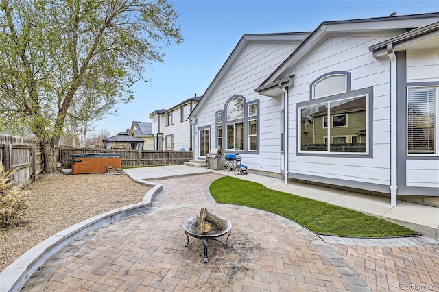 exterior space with a hot tub, a fenced backyard, and area for grilling