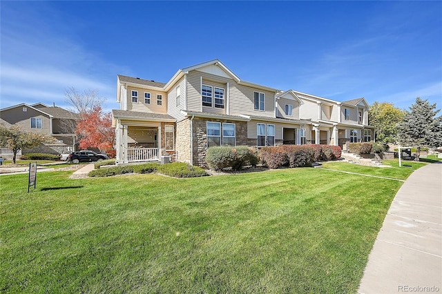 townhome / multi-family property with a porch and a front lawn