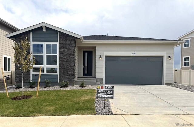 304 W Owen Ave, Keenesburg, CO 80643 - view of front of home featuring driveway, a front yard, and an attached garage