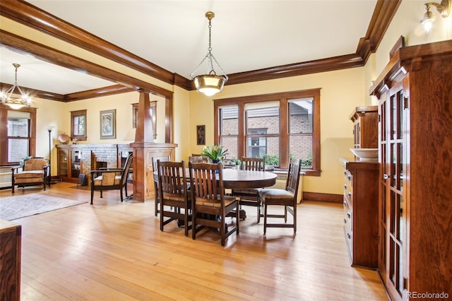 dining room with crown molding, light wood finished floors, and baseboards