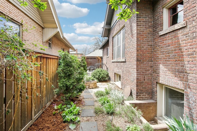 view of home's exterior with brick siding and fence