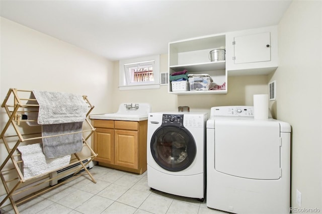 washroom featuring independent washer and dryer, visible vents, cabinet space, a sink, and light tile patterned floors