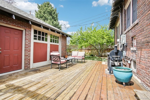wooden deck with an outdoor living space, fence, and area for grilling