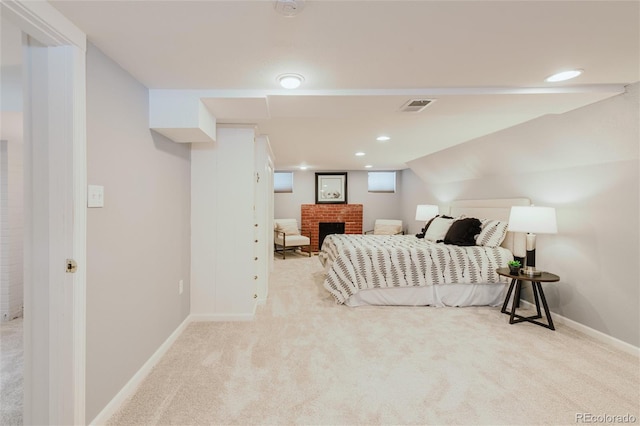 carpeted bedroom with a fireplace and vaulted ceiling