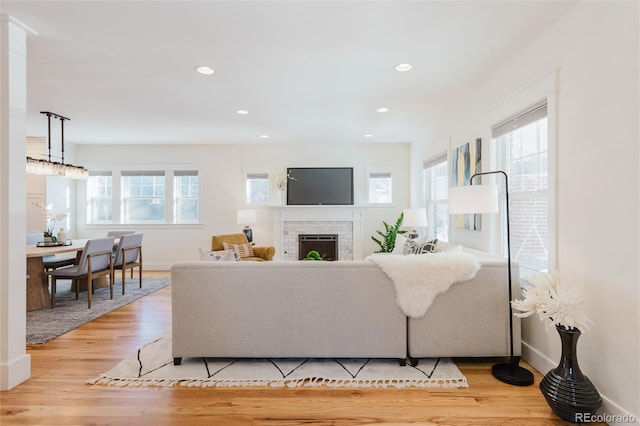 living room with light wood-type flooring and a brick fireplace