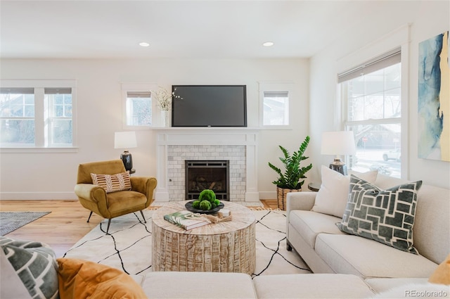 living room with light hardwood / wood-style flooring and a brick fireplace