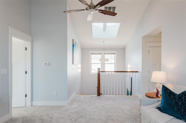 living area with carpet flooring, a skylight, ceiling fan, and high vaulted ceiling