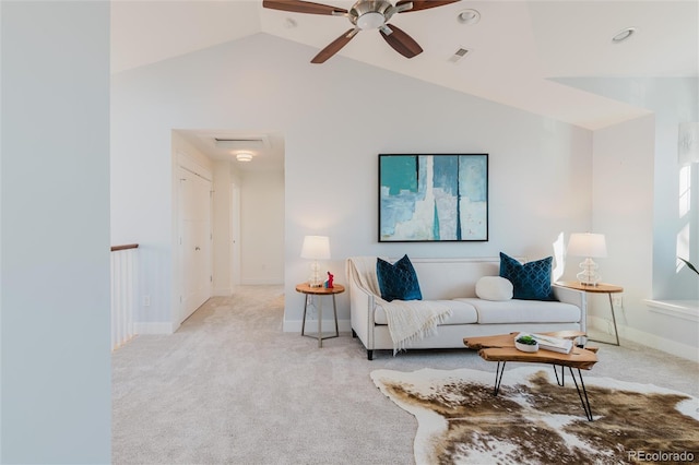 carpeted living room with ceiling fan and vaulted ceiling