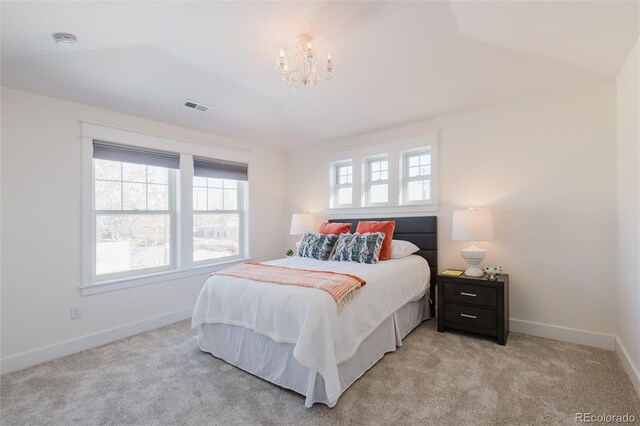 bedroom featuring lofted ceiling, light carpet, and an inviting chandelier