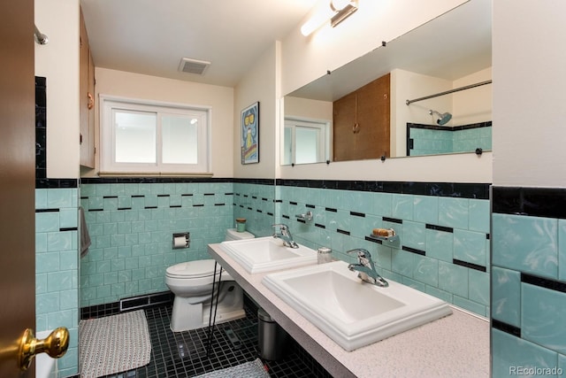 7820 Grove St, Westminster, CO 80030 - bathroom featuring tile patterned floors, tile walls, a wainscoted wall, a shower, and double vanity