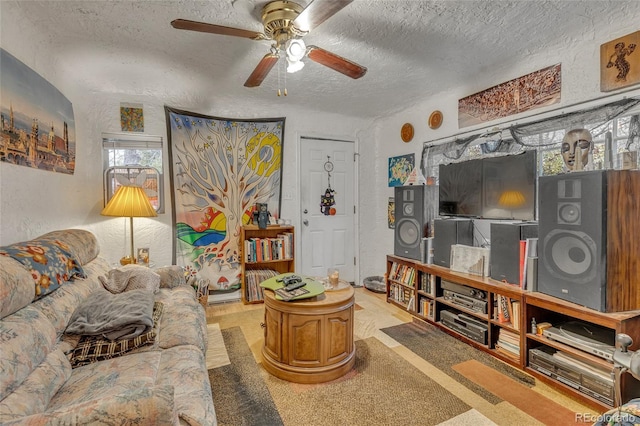 living room with ceiling fan and a textured ceiling