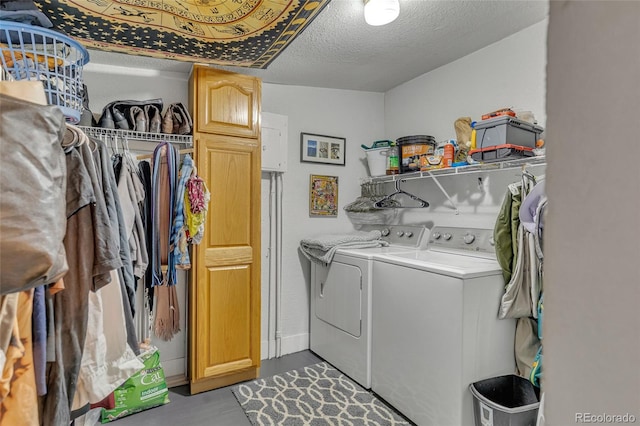 clothes washing area featuring cabinets, washer and dryer, and a textured ceiling