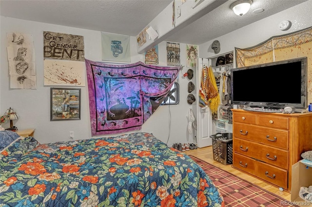 bedroom featuring wood-type flooring and a textured ceiling