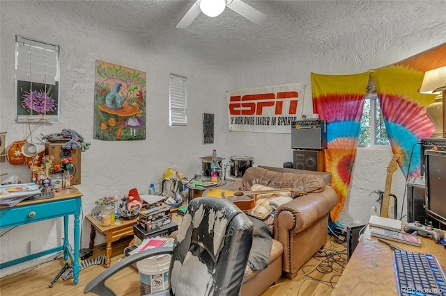 bedroom featuring hardwood / wood-style flooring, ceiling fan, and a textured ceiling