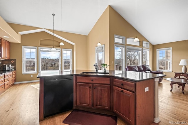 kitchen featuring black dishwasher, vaulted ceiling, a sink, and a healthy amount of sunlight