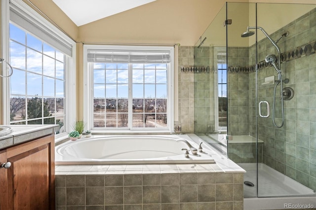 bathroom featuring lofted ceiling, a garden tub, a shower stall, and vanity