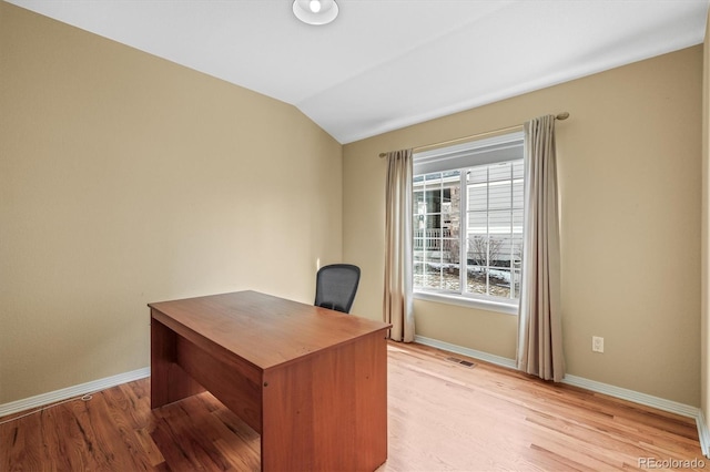 unfurnished office with lofted ceiling, visible vents, light wood-style flooring, and baseboards