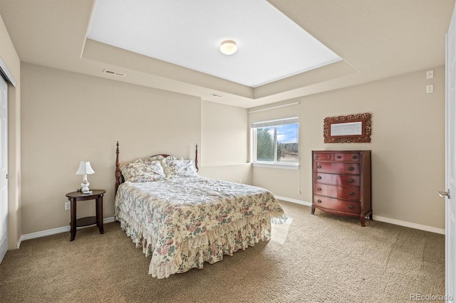 carpeted bedroom with baseboards, visible vents, and a raised ceiling