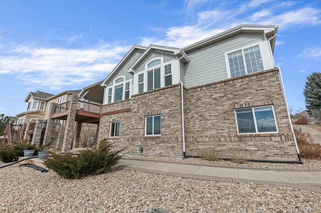 exterior space with brick siding and a balcony