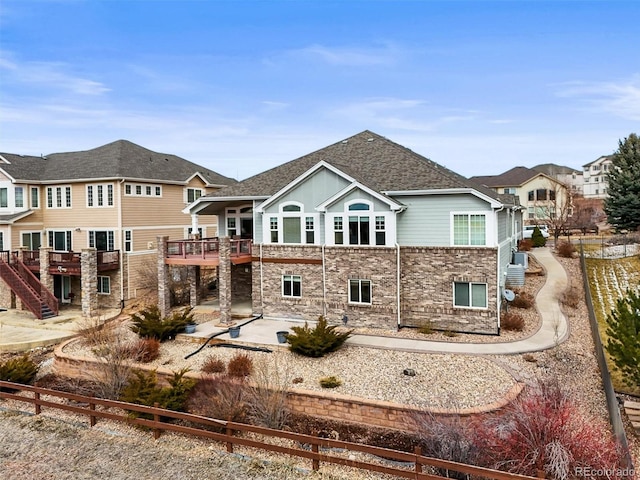 back of property with a patio and roof with shingles