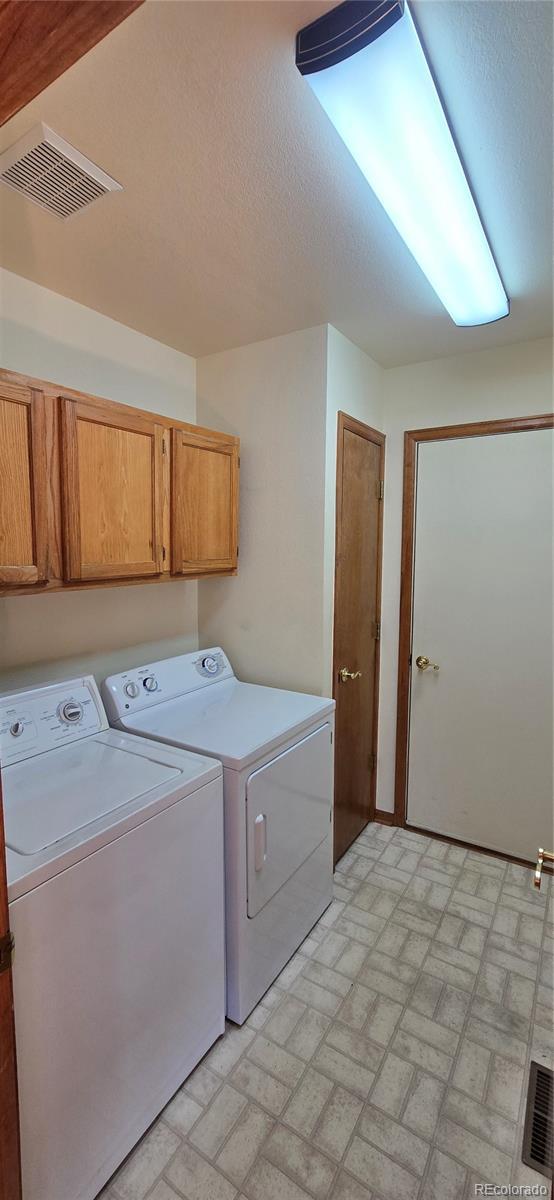 laundry room with separate washer and dryer and cabinets