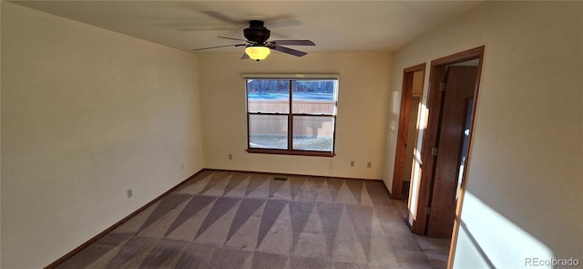 empty room featuring ceiling fan and carpet