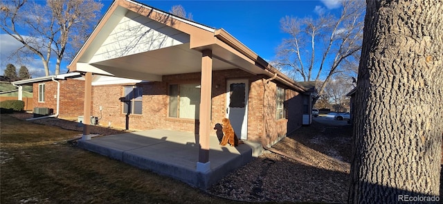 view of side of property featuring cooling unit and a patio