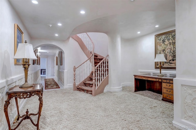 entryway with carpet, stairs, arched walkways, and recessed lighting