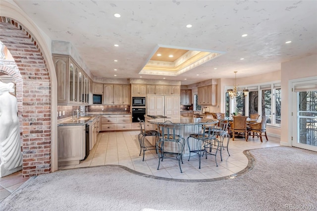 kitchen featuring light tile patterned floors, black appliances, and a tray ceiling