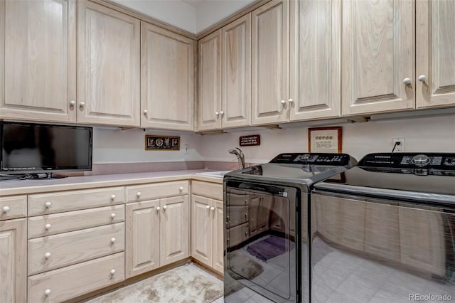 clothes washing area featuring independent washer and dryer, a sink, and cabinet space