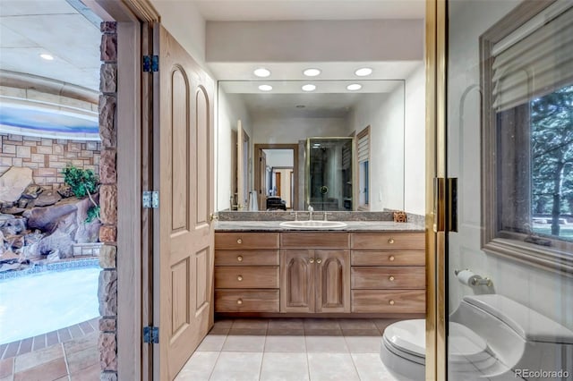 bathroom with vanity, toilet, tile patterned floors, and a washtub