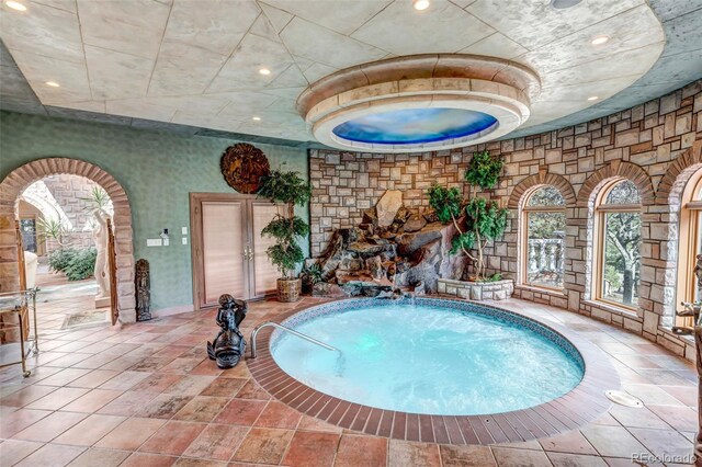 view of pool with an indoor hot tub