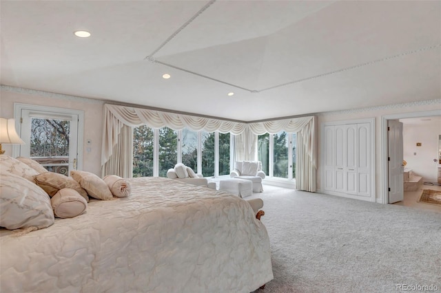 carpeted bedroom featuring lofted ceiling, access to exterior, multiple windows, and ensuite bathroom