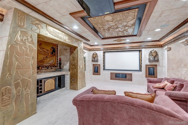 home theater room featuring carpet, ornamental molding, and a tray ceiling