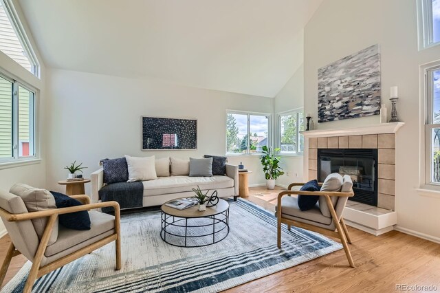 744 Owl Dr, Louisville, CO 80027 - living room with high vaulted ceiling, a fireplace, wood finished floors, and plenty of natural light