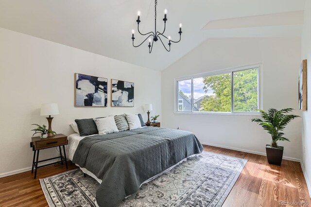 744 Owl Dr, Louisville, CO 80027 - bedroom with lofted ceiling, a chandelier, wood finished floors, and baseboards