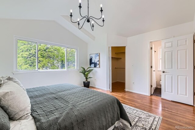 744 Owl Dr, Louisville, CO 80027 - bedroom featuring a chandelier, a spacious closet, lofted ceiling, wood finished floors, and baseboards